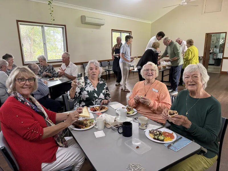 Church community members seated together for a shared meal in Abbey Hall