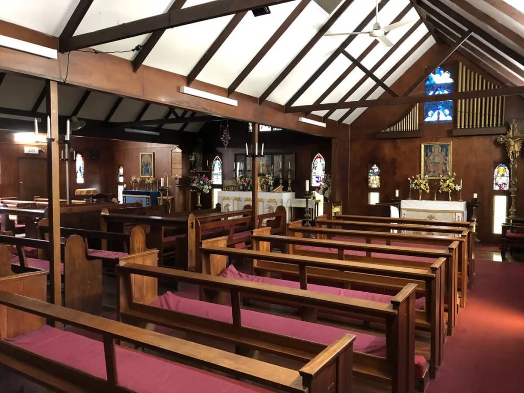 Heritage chapel interior with timber pews and stained glass