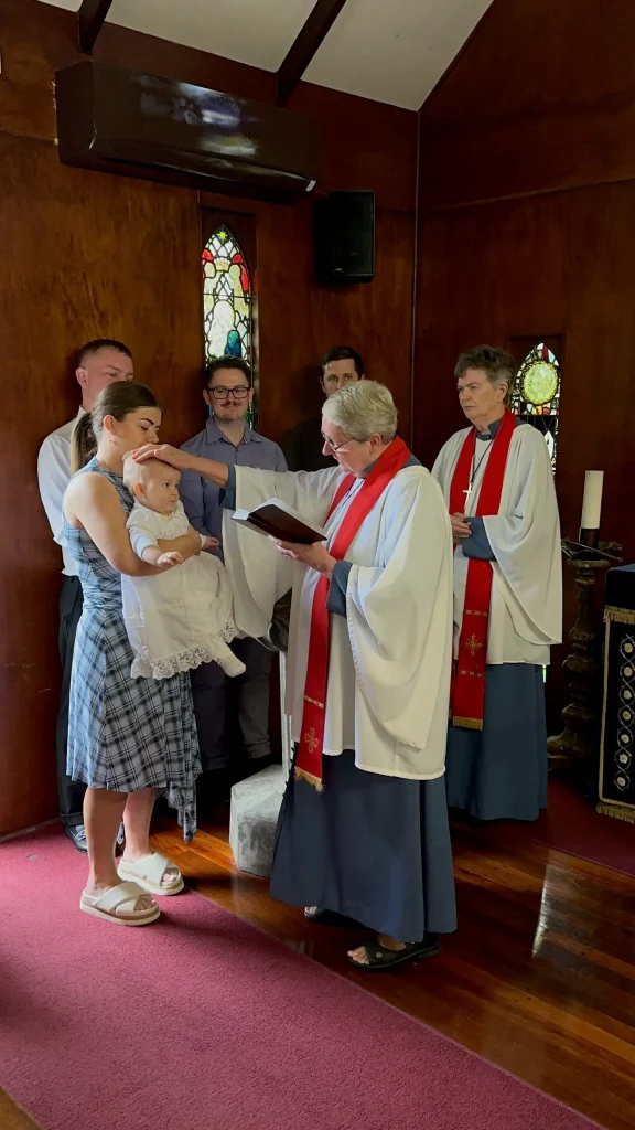 Family and clergy during a baptism ceremony at The Abbey Church