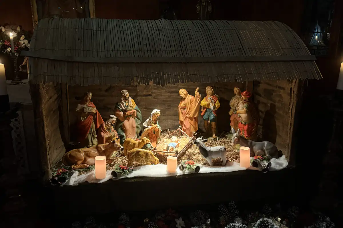 The Christmas crib and Nativity figures lit by candlelight inside The Abbey Church.