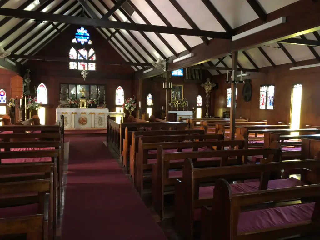 Nave, timber pews and stained glass inside The Abbey Church