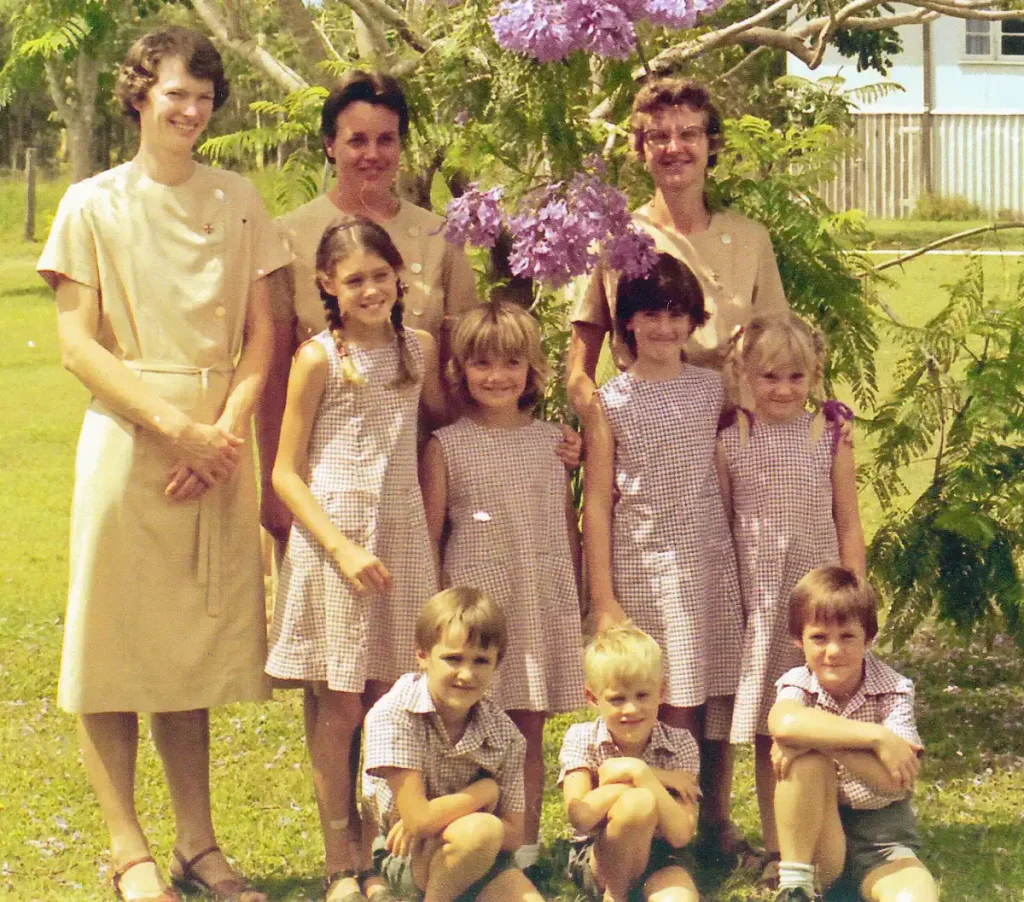 The first students and teachers of St Michael's College, gathered beneath a jacaranda tree