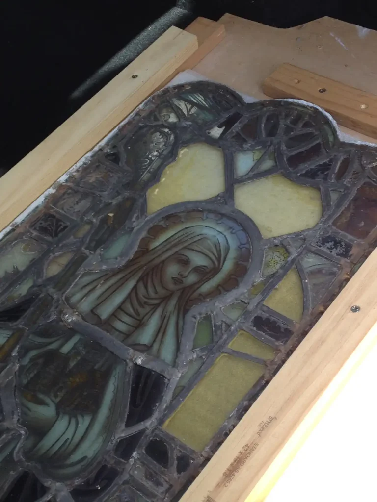 Saint Hilda Stained Glass Panel Packed for Conservation Leaded stained glass panel of St Hilda on a timber support during the Abbey Church heritage building conservation programme